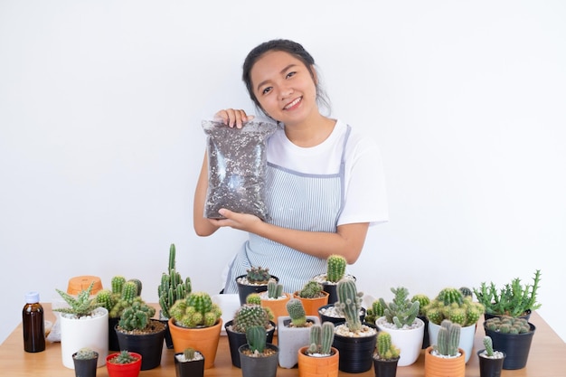 Chica sonriente feliz con tierra para macetas para cactus