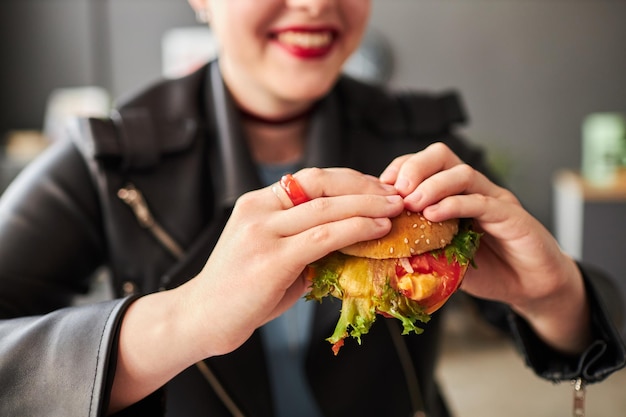 La chica sonriente con la hamburguesa