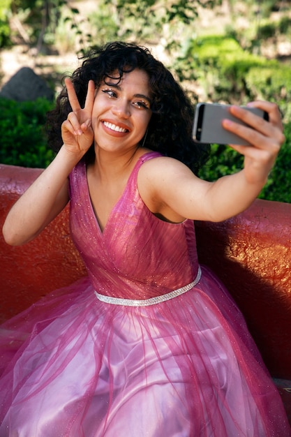 Chica sonriente tomando selfie ángulo alto