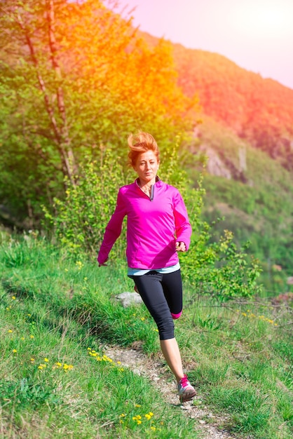 Chica con una sonrisa alegre corre en la naturaleza