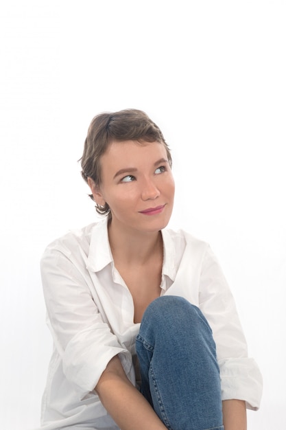 Chica en sonrisas y mira hacia arriba. La mujer de pelo corto piensa en algo.