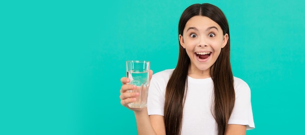 Chica sorprendida bebe un vaso de agua para mantenerse hidratada y mantener el equilibrio diario del agua beber agua Banner de niña con vaso de agua retrato de estudio con espacio de copia