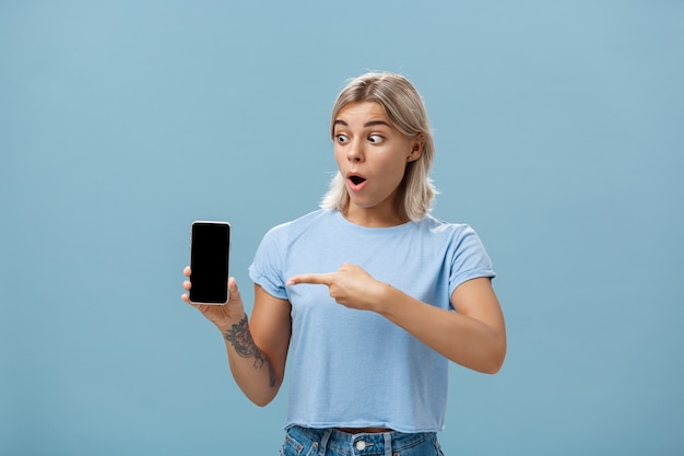 Chica sorprendida con nuevo teléfono inteligente fresco recibido en cumpleaños.