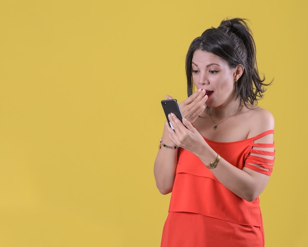 Chica sorprendida con smartphone en mano