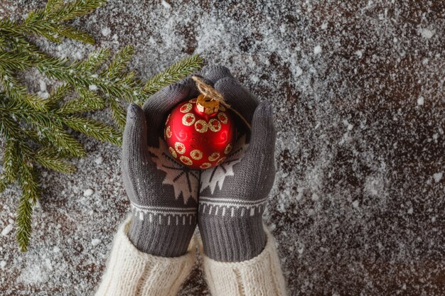 Chica sostenga la bola de Navidad en manos