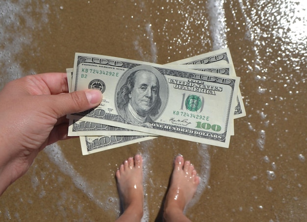 Chica sosteniendo un billete de 300 dólares en el fondo del océano