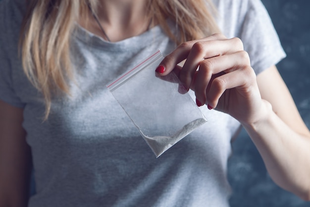 Chica sosteniendo una bolsa de drogas