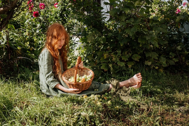 Chica sosteniendo una canasta de tomates verdes