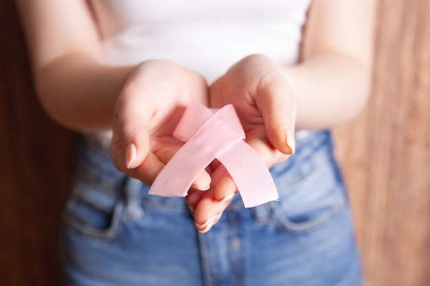 Chica sosteniendo cáncer de signo de cinta roja