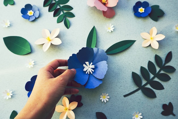 Foto chica sosteniendo una flor artesanal de papel hecha a mano.