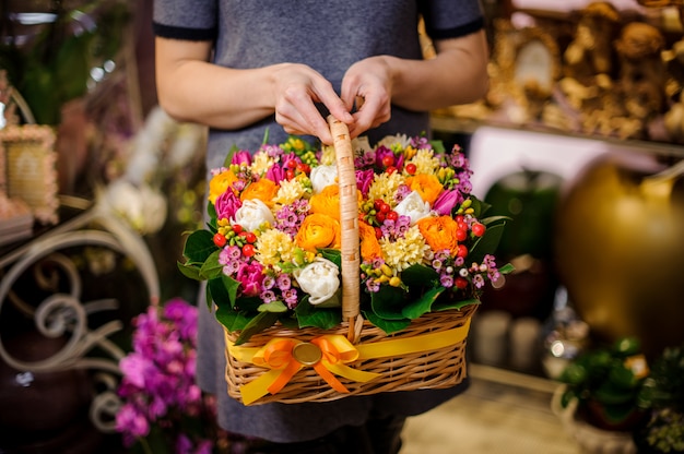 Chica sosteniendo una hermosa canasta de flores de primavera multicolores