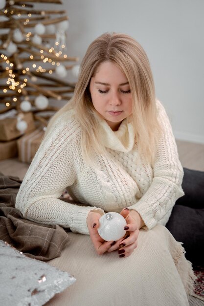 Foto chica sosteniendo un juguete de árbol de navidad en sus manos interior de año nuevo