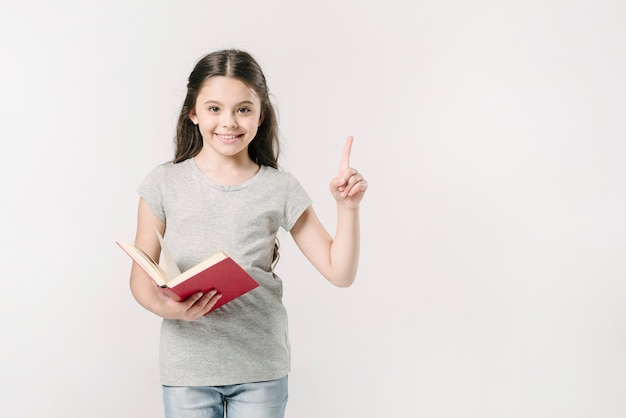 Chica sosteniendo el libro con el dedo levantado