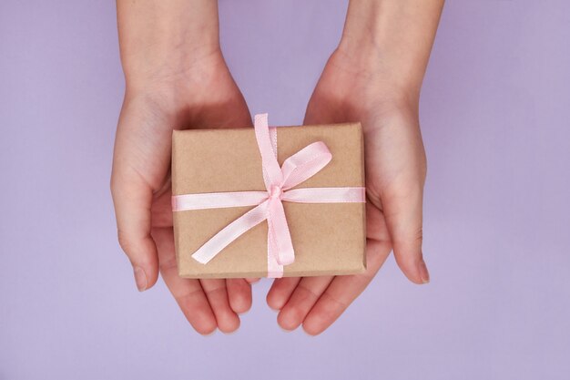 Chica sosteniendo en las manos caja de regalo de Navidad o año nuevo