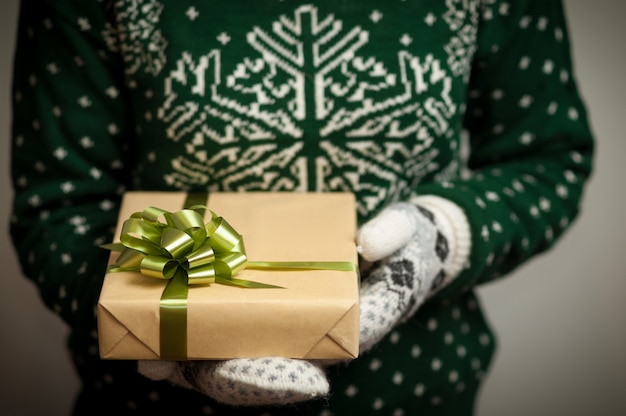 Chica sosteniendo un regalo de Navidad.