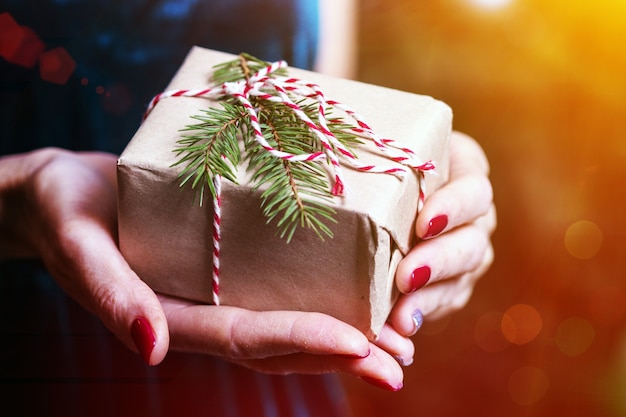 Chica sosteniendo regalos de Navidad en manos feliz año nuevo