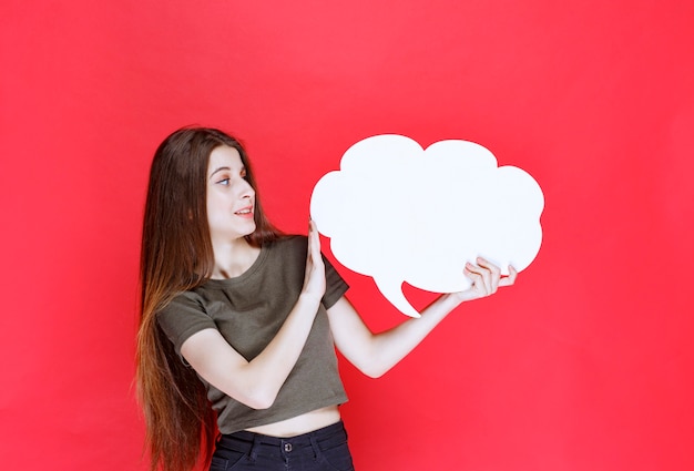 Chica sosteniendo un tablero de información de forma de nube y negándose a usarlo.