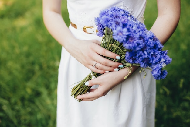 Chica sostiene ramo de flores silvestres en la boda