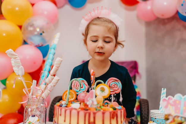 Chica con su pastel de cumpleaños feliz cumpleaños carda linda niña celebra cumpleaños rodeada de regalos