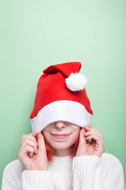 Chica en suéter blanco y gorro de santa