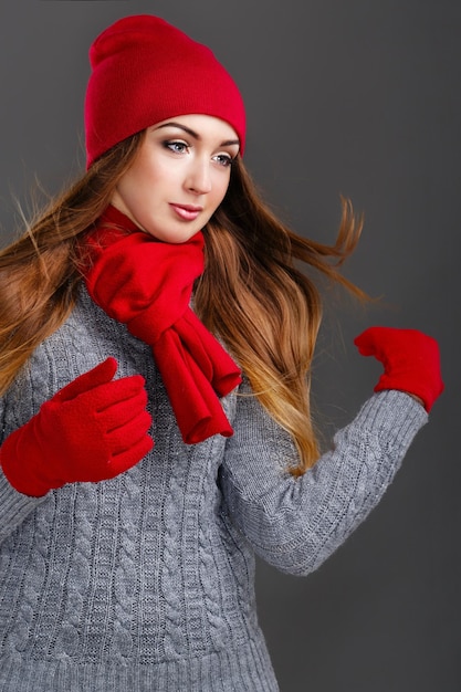 Chica en suéteres de punto, guantes y sombreros