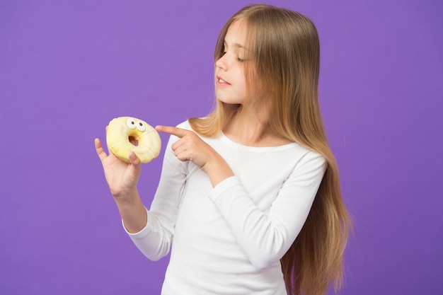 Chica sujetando donut esponjoso bagel glaseado con ojos postre creativo Niño comiendo glaseado