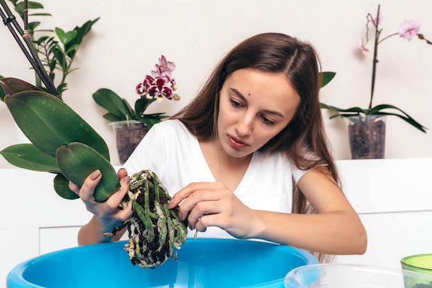 Chica sujetando la raíz de la flor de la orquídea