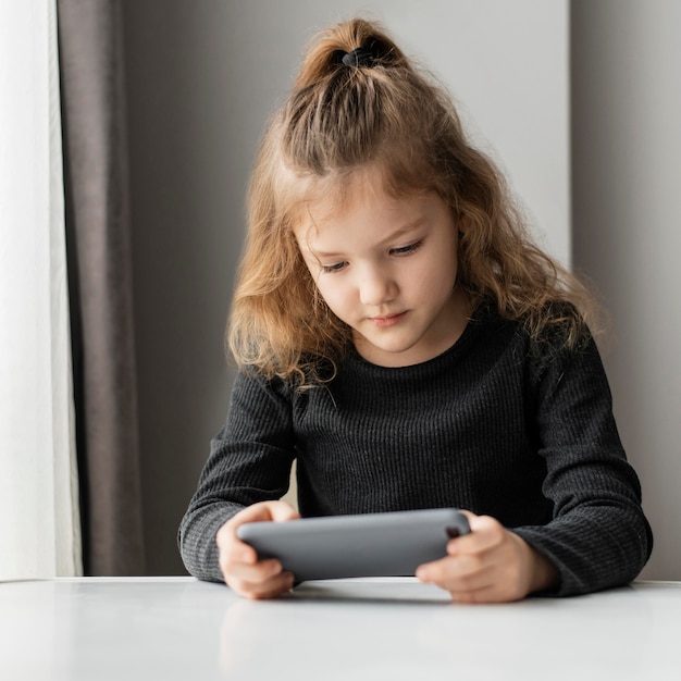 Foto chica sujetando el teléfono de tiro medio