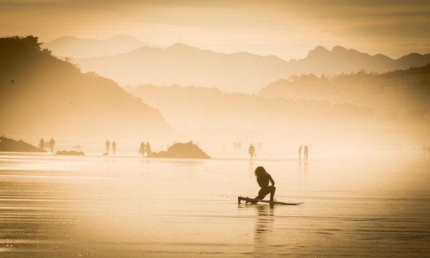 Chica surfista en la playa preparándose para empezar