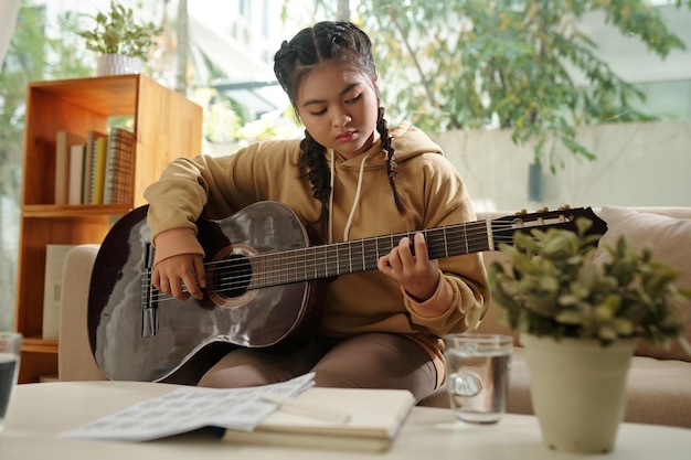 Chica talentosa tocando la guitarra