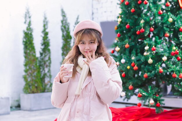 La chica con una taza de agua caliente en el cálido invierno