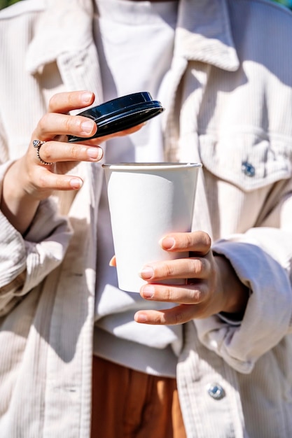 Chica con una taza de café para llevar Chica elegante sosteniendo una taza de papel con bebida caliente al aire libre Estilo de vida