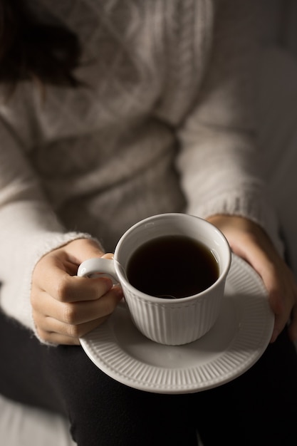 Chica con taza de té, detalles de manos