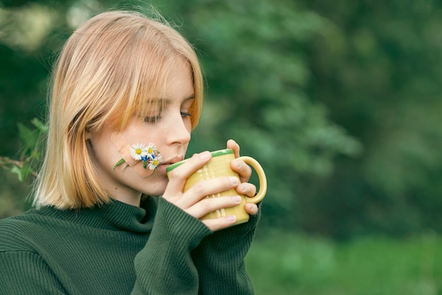 Chica con taza de té de hierbas en primavera