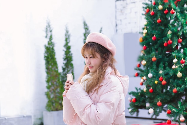 La chica con un teléfono en el cálido invierno