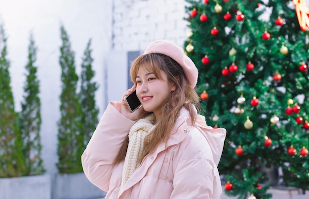 La chica con un teléfono en el cálido invierno