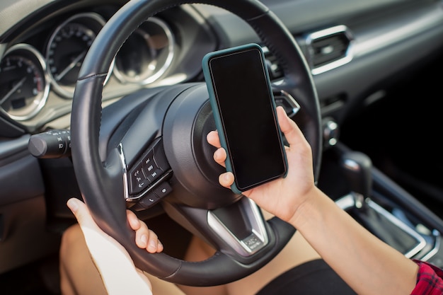 Chica con teléfono inteligente en auto