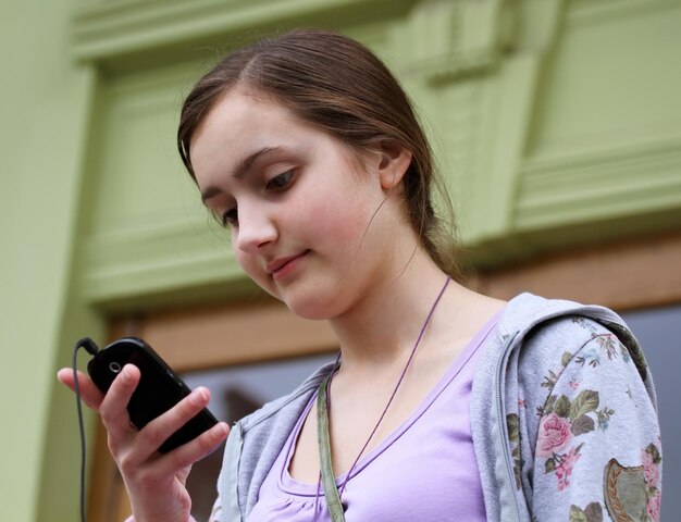 Chica con un teléfono móvil lee el mensaje