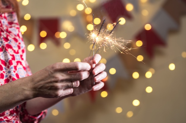 Foto chica tiene luces de bengala - feliz navidad y felices fiestas