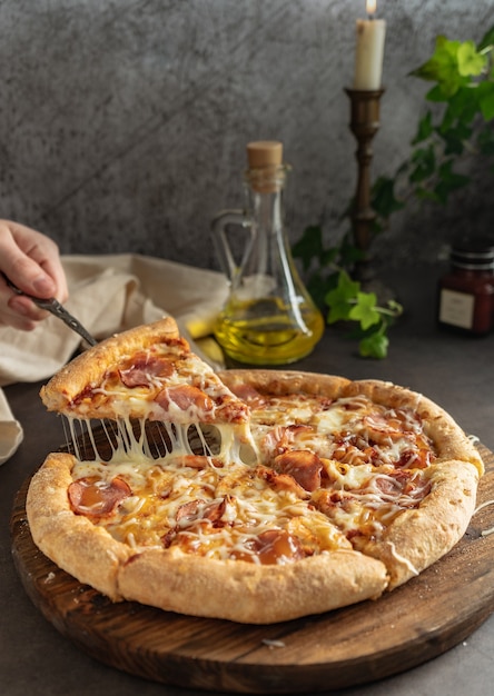 Chica tira una rebanada de pizza con estiramiento de queso derretido