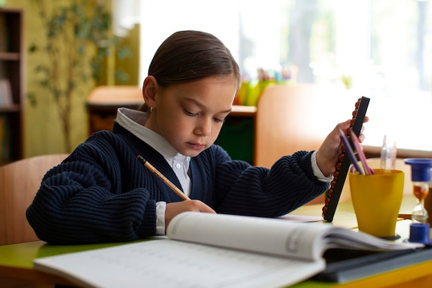 Foto chica de tiro medio aprendiendo matemáticas en la escuela.