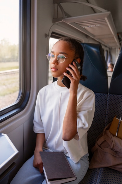 Foto chica de tiro medio viajando en tren.