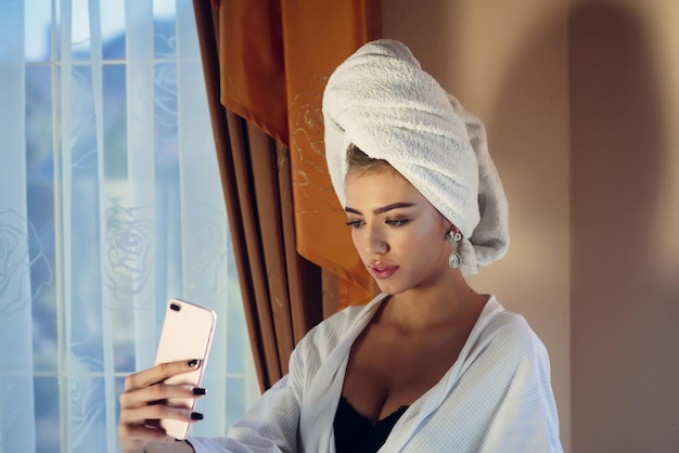 Chica con toalla en la cabeza tomando selfie, después de spa
