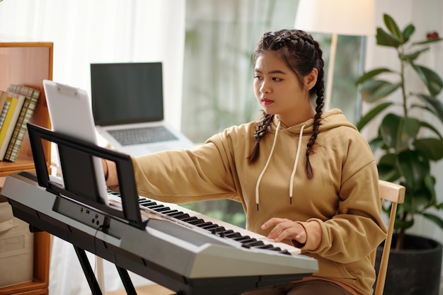 Chica tocando la canción en el sintetizador