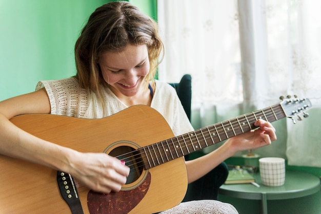 Chica tocando una guitarra acústica