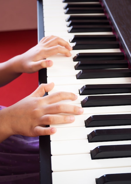 Chica tocando el piano. Closeup mano y dedo