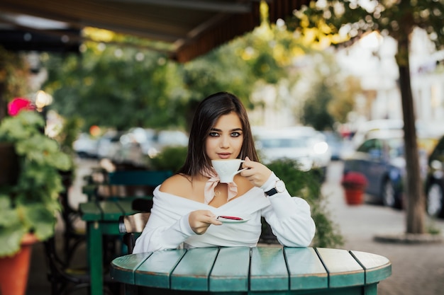 Chica tomando café y sonriendo