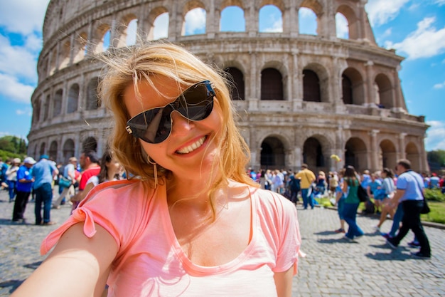 Chica tomando foto selfie frente al Coliseo en Roma