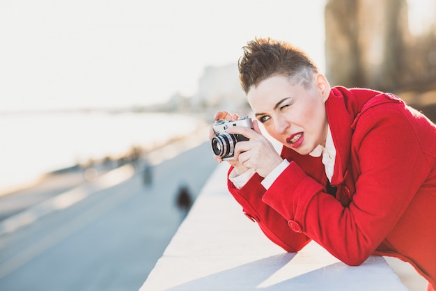 Chica tomando fotos en el paseo marítimo al atardecer