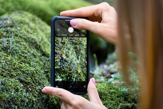 Chica tomando fotos en un teléfono móvil